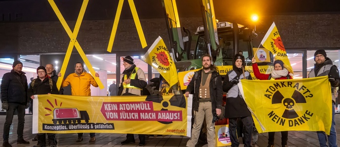 Foto: mehrere Mesnchen demonstrieren mit Transparenten, gelben Xen und einen Trecker gegen Atommüll